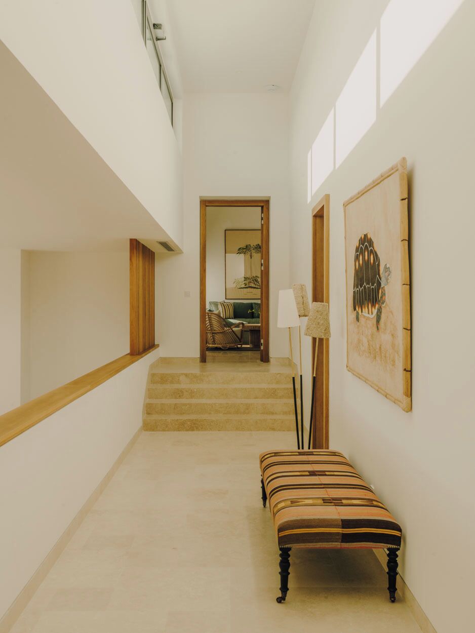 A staircase with a bench, a lamp, and a framed artwork on the wall.