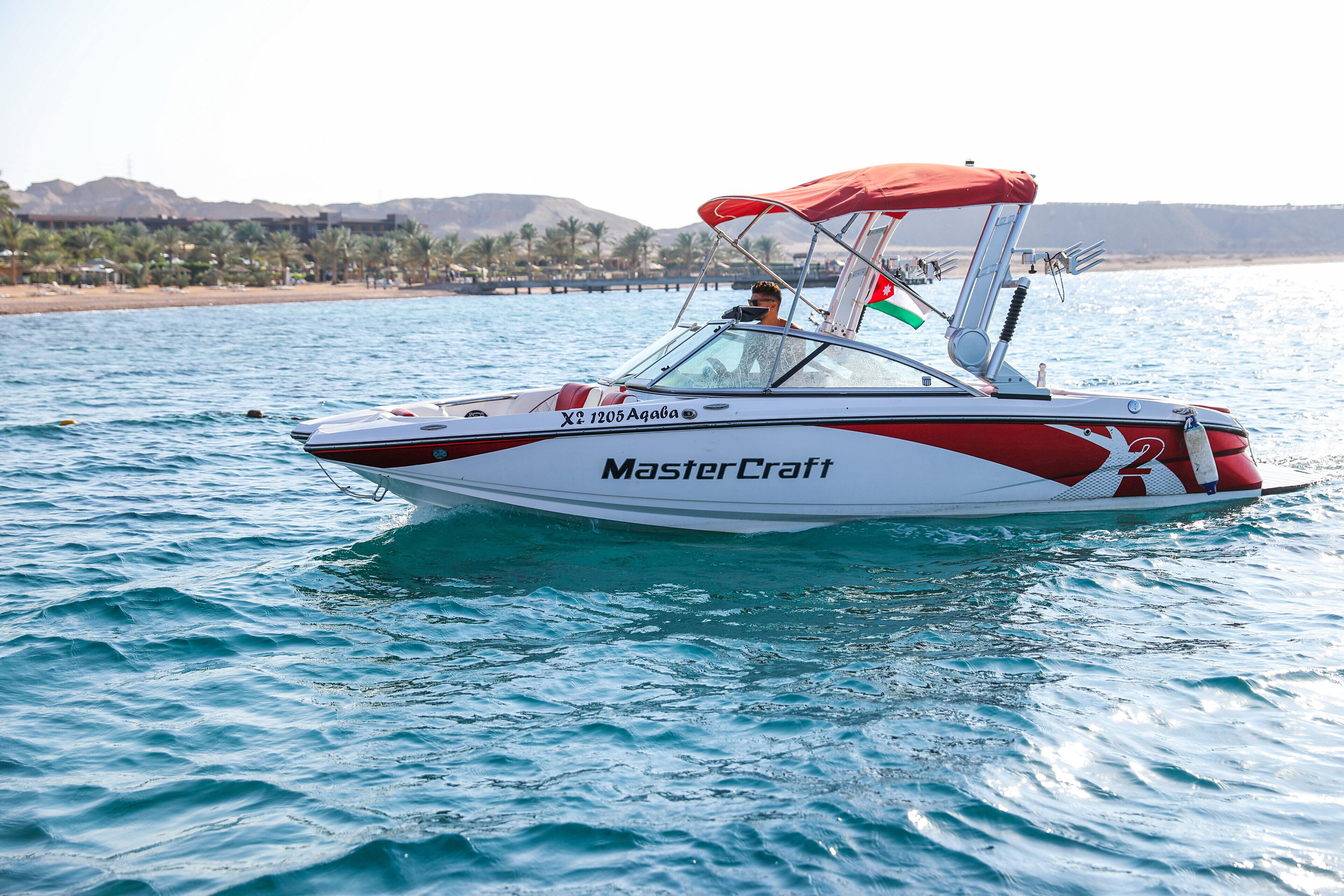 Un bote a motor con un toldo rojo y el nombre 