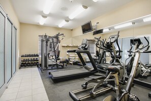A gym with treadmills, elliptical machines, and free weights.