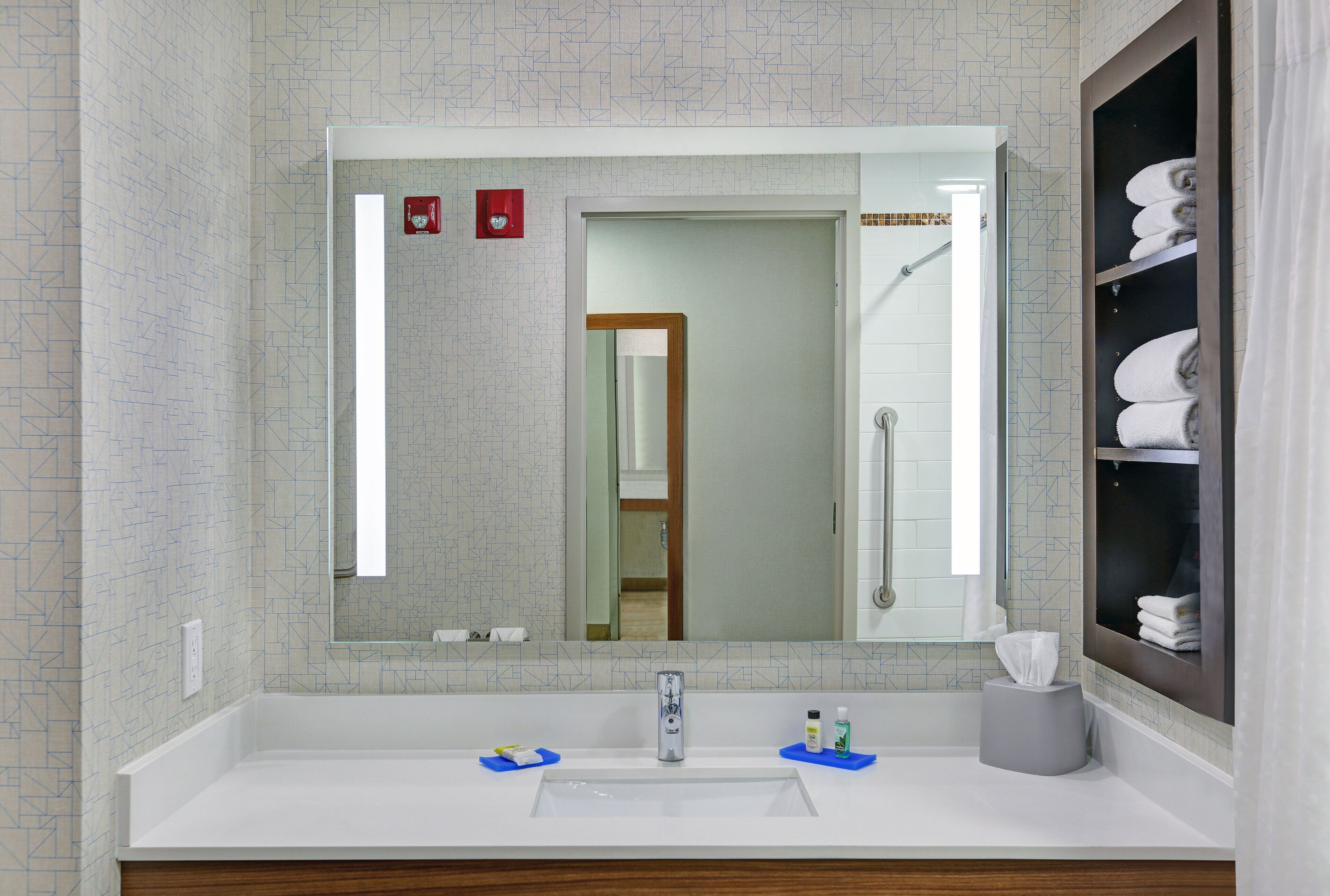 A bathroom with a white sink, a mirror, and a towel rack.