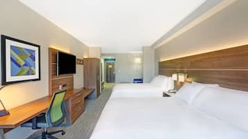 Une chambre d’hôtel avec deux lits, un bureau, une chaise, une télévision et une lampe.