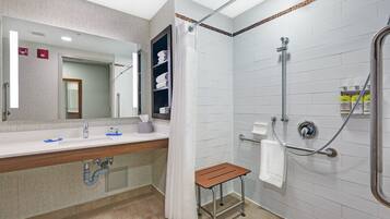 A modern bathroom with a shower, a sink, and a mirror.