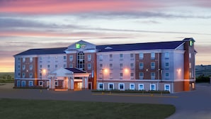 A large, multi-story hotel with a central entrance and a parking lot. - Holiday Inn Express Hotel & Suites SWIFT CURRENT by IHG (Swift Current)