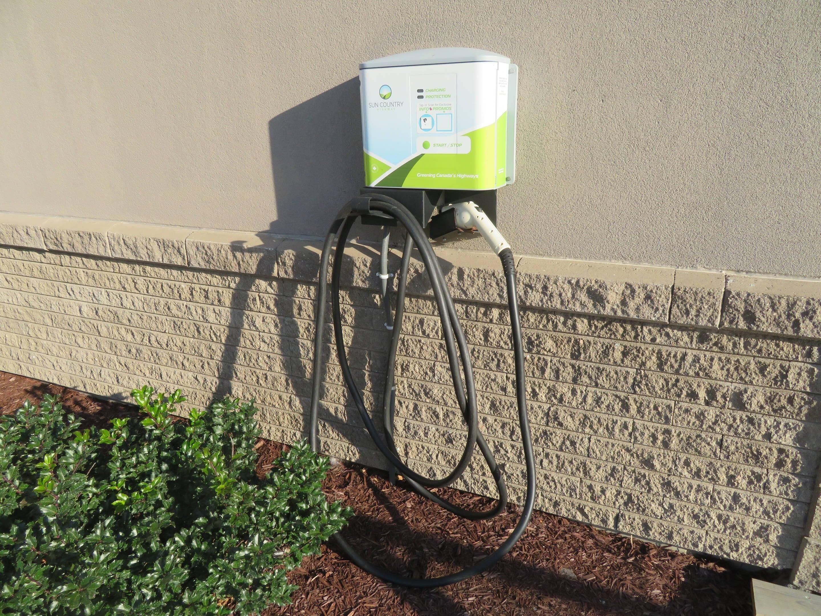 Eine Solar-Ladestation mit angeschlossenem Schlauch, an einer Wand befestigt.
