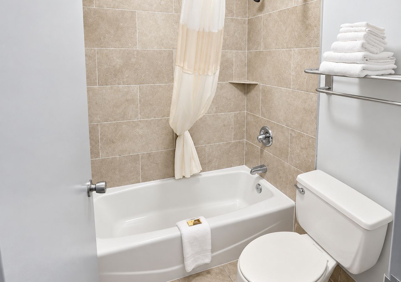 A bathroom with a bathtub, toilet, and towel rack.
