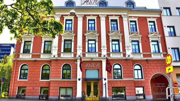 A red building with a sign reading "ASTOR" and a flag. - Hotel Astor (Vaasa)