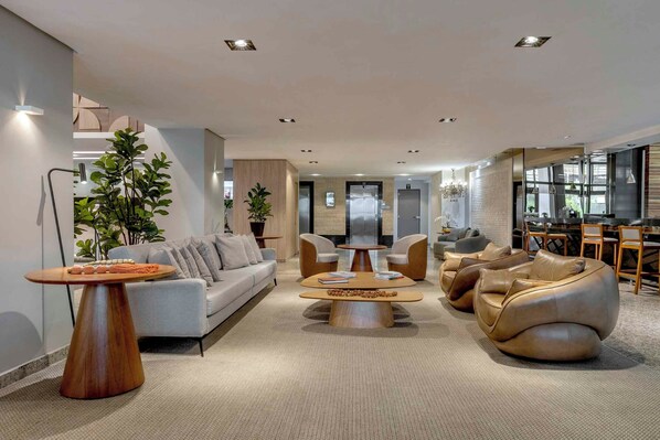 A modern living room with a sofa, two coffee tables, and a large bean bag. - SJ Premium By Atlantica (Goiania)
