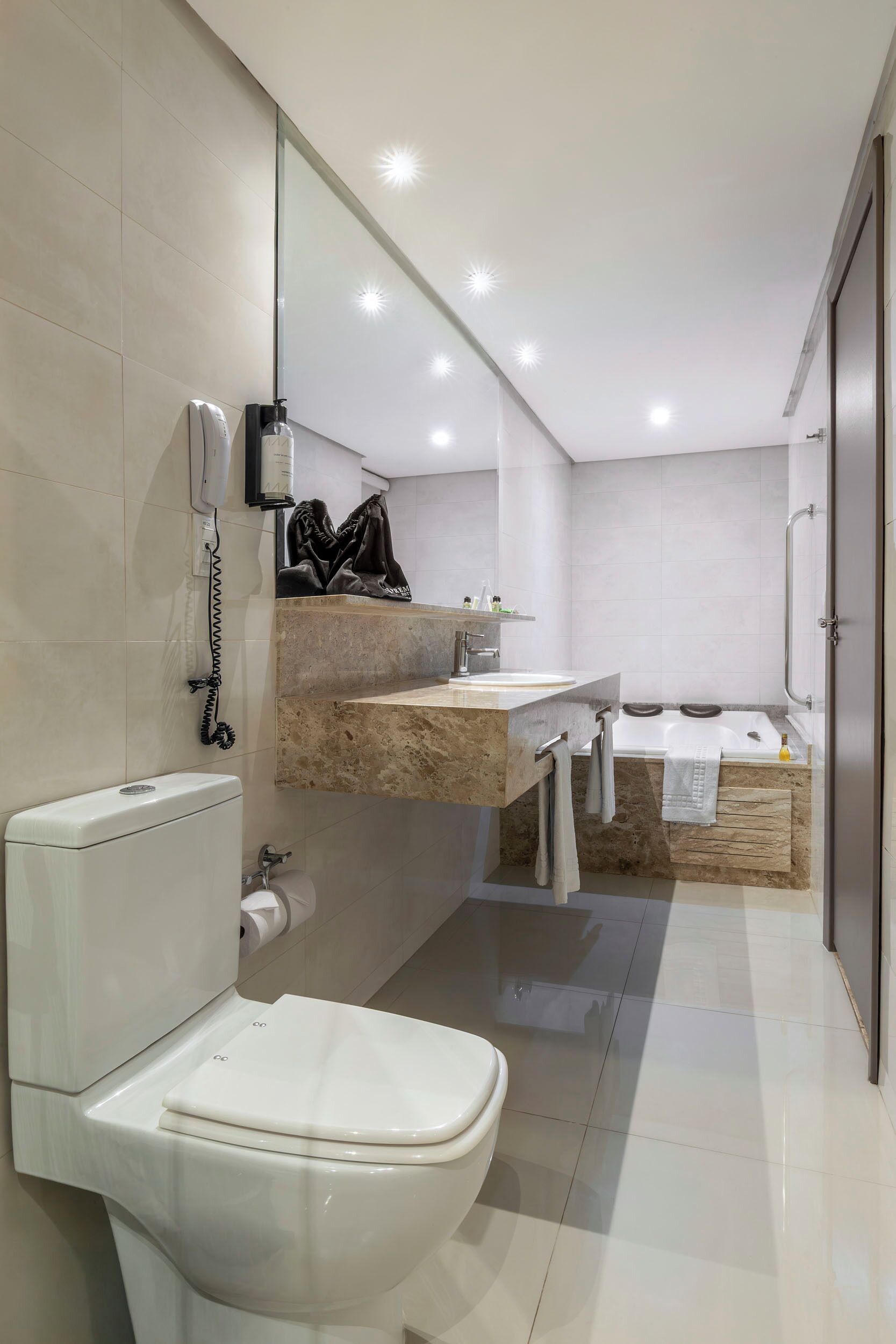 Uma casa de banho moderna com sanita, lavatório e banheira.
