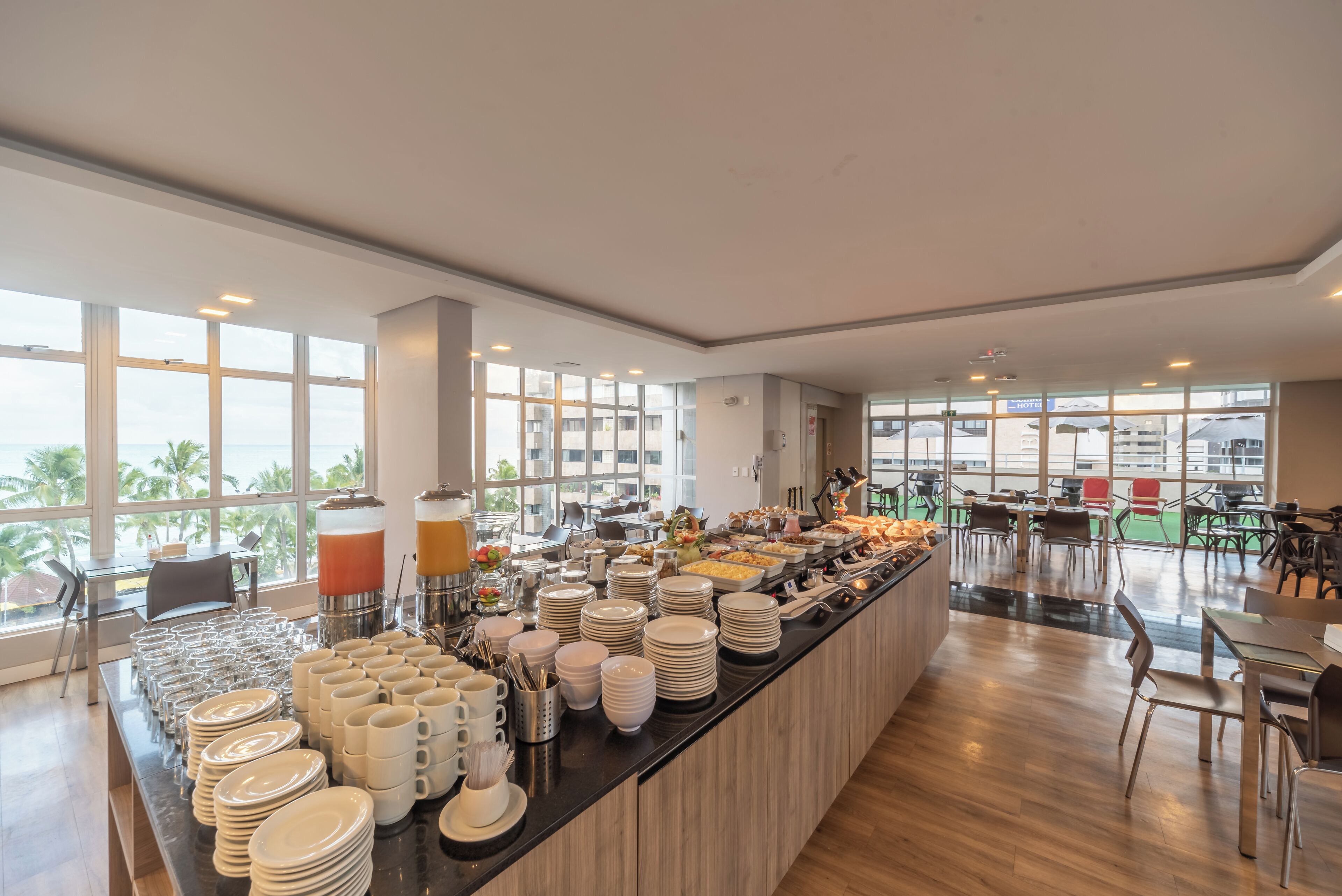 A buffet setup with various food items and a seating area with tables and chairs.