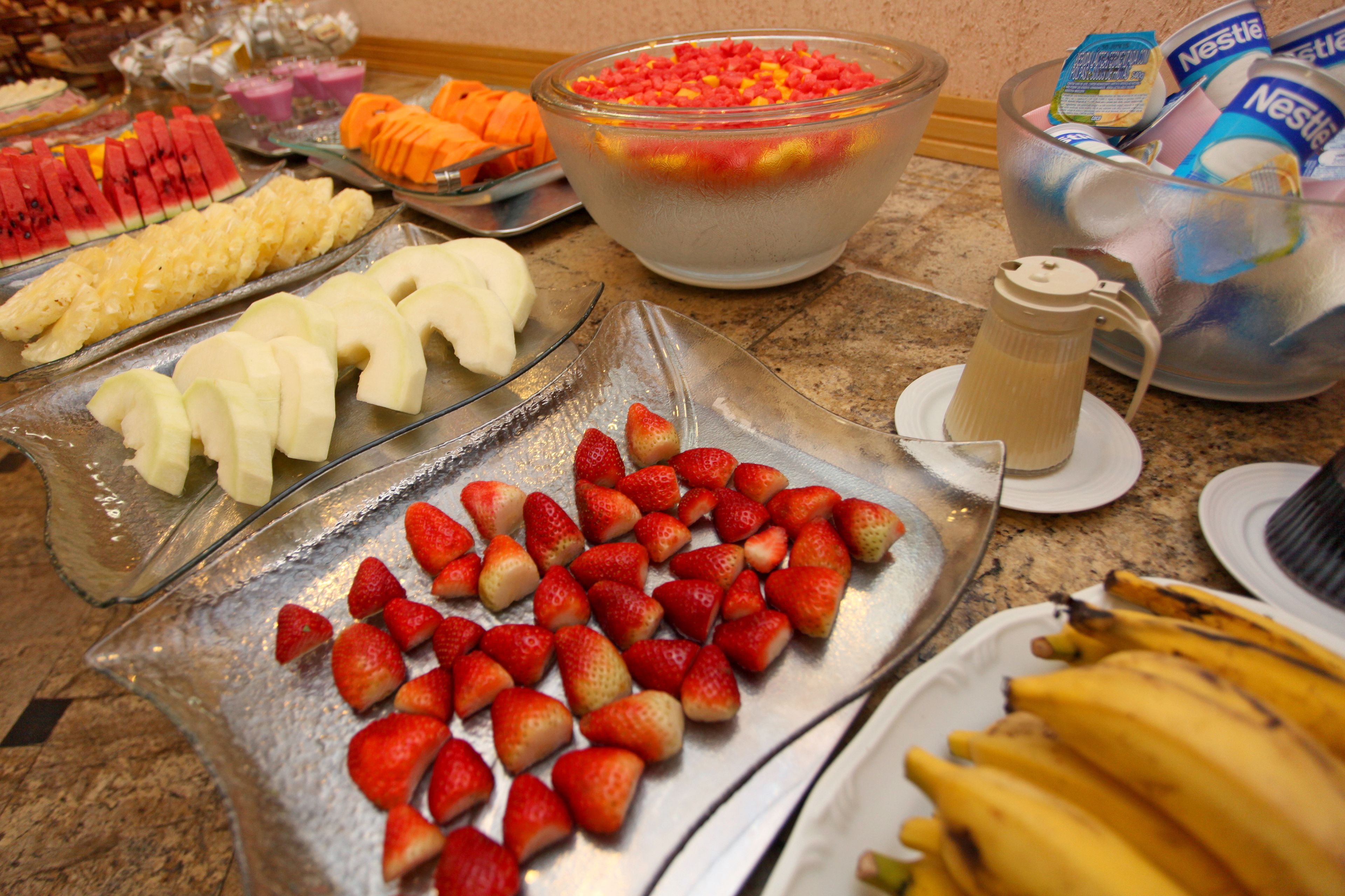 A buffet with various fruits and a pitcher of juice.