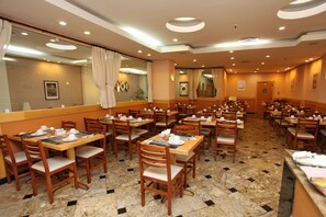 Ein Restaurant mit mehreren Tischen und Stühlen, ansprechend aufgestellt in einem geräumigen Ambiente.