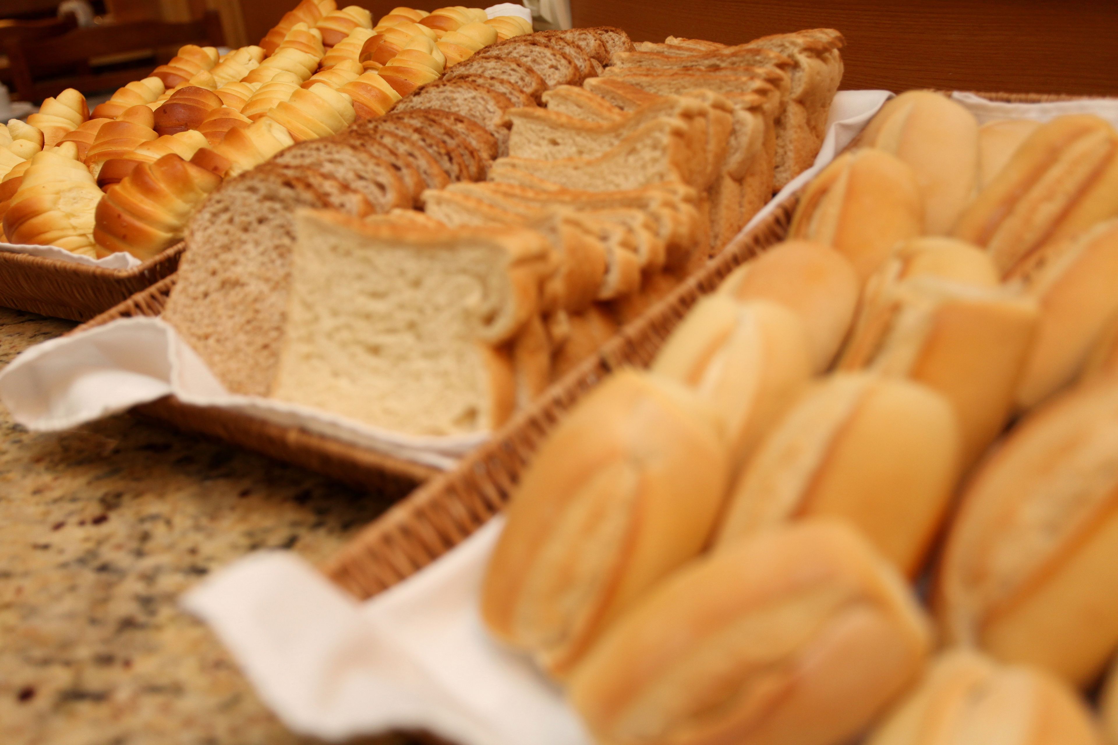 Diverse soorten brood en gebak, uitgestald op een aanrecht.