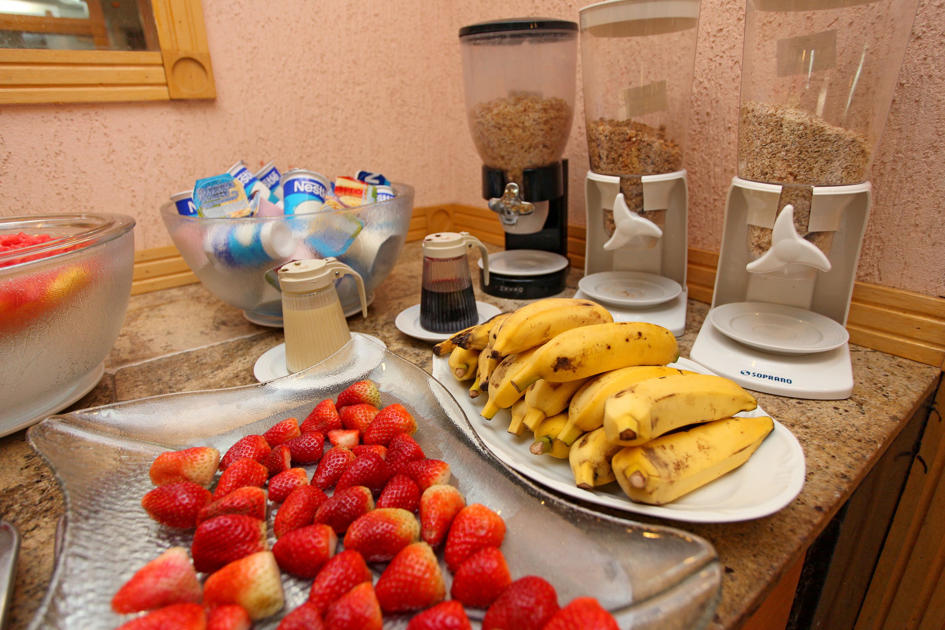 Un buffet de petit-déjeuner proposant divers fruits, une machine à café et un mixeur.