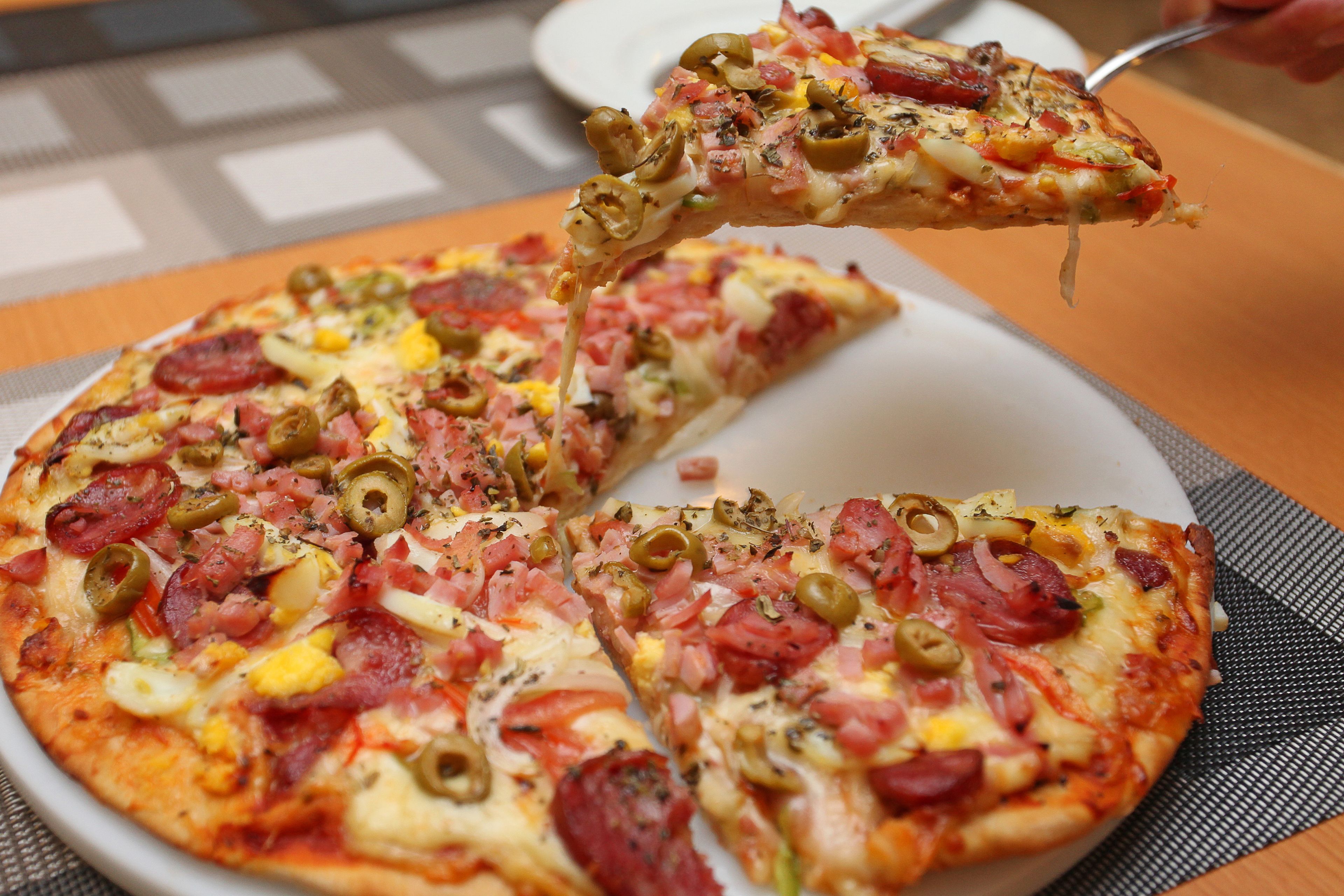 A pizza with various toppings on a white plate.