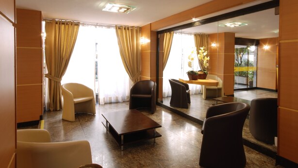 A hotel lobby with a seating area, a coffee table, and a view through a glass door. - Hotel Vermont Ipanema (Rio de Janeiro)
