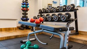 A gym with a bench press, dumbbells, and a rack of weights. - Hotel Vermont Ipanema (Rio de Janeiro)