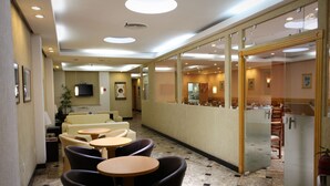 A hotel lobby with seating areas, a reception desk, and a television. - Hotel Vermont Ipanema (Rio de Janeiro)