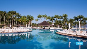 A large swimming pool with lounge chairs and palm trees in the background. - Vila Gale Angra - All Inclusive (Angra dos Reis)