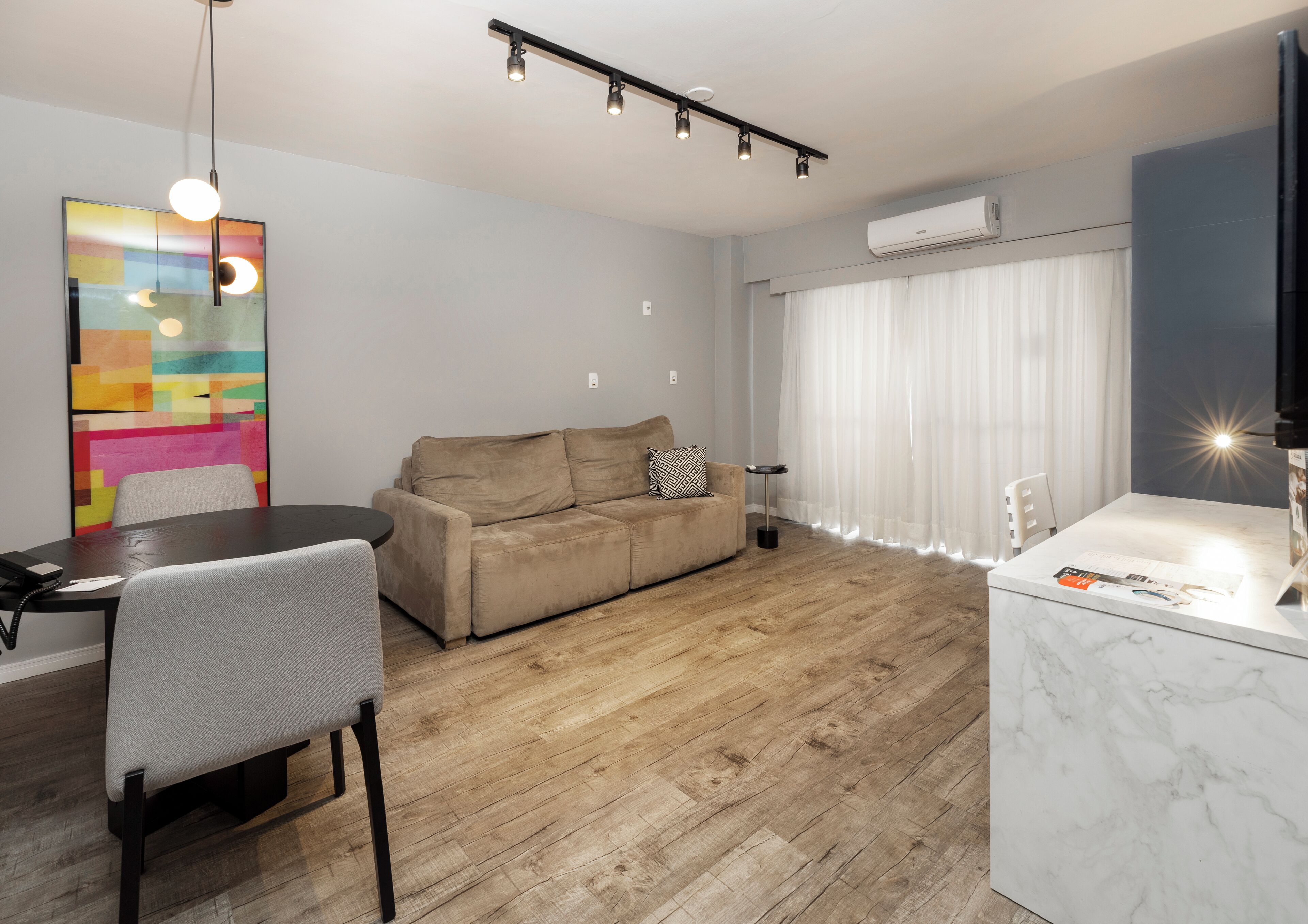 En moderne stue med sofa, spisebord og et køkkenområde.
