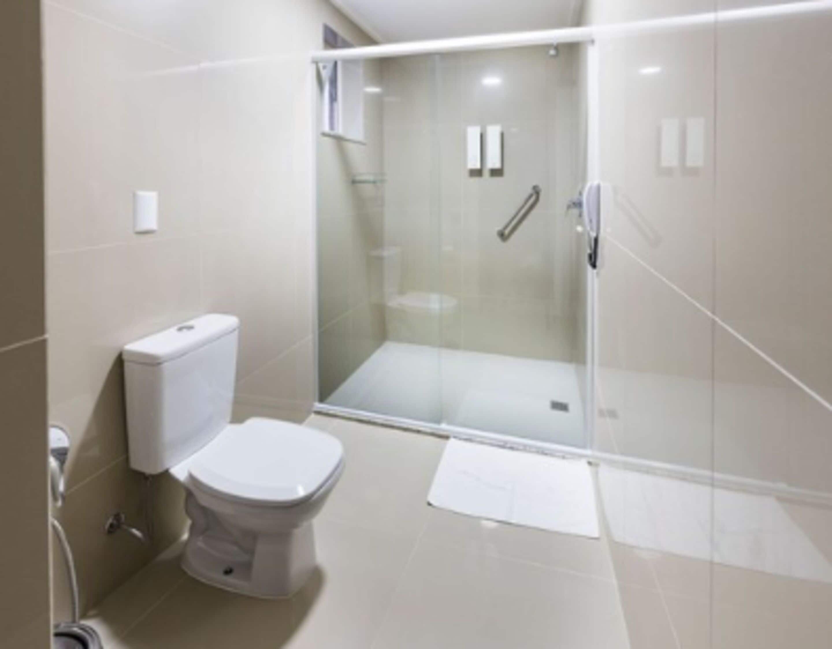 Un baño moderno con ducha envuelta en vidrio, inodoro y bidé.