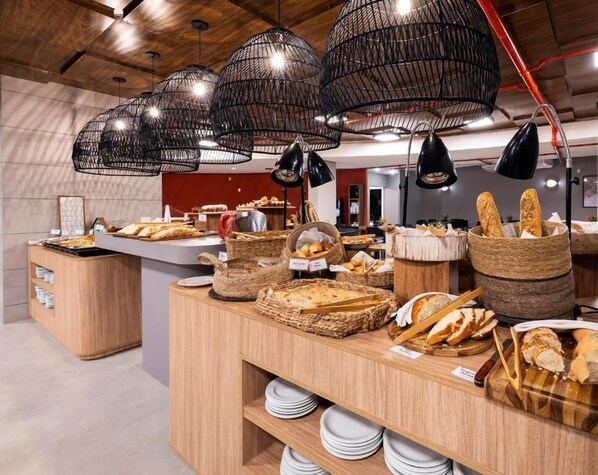A buffet area with various breads and pastries displayed on wooden counters and baskets.