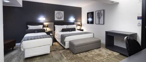 A modern bedroom with two beds, a desk, and a chair.