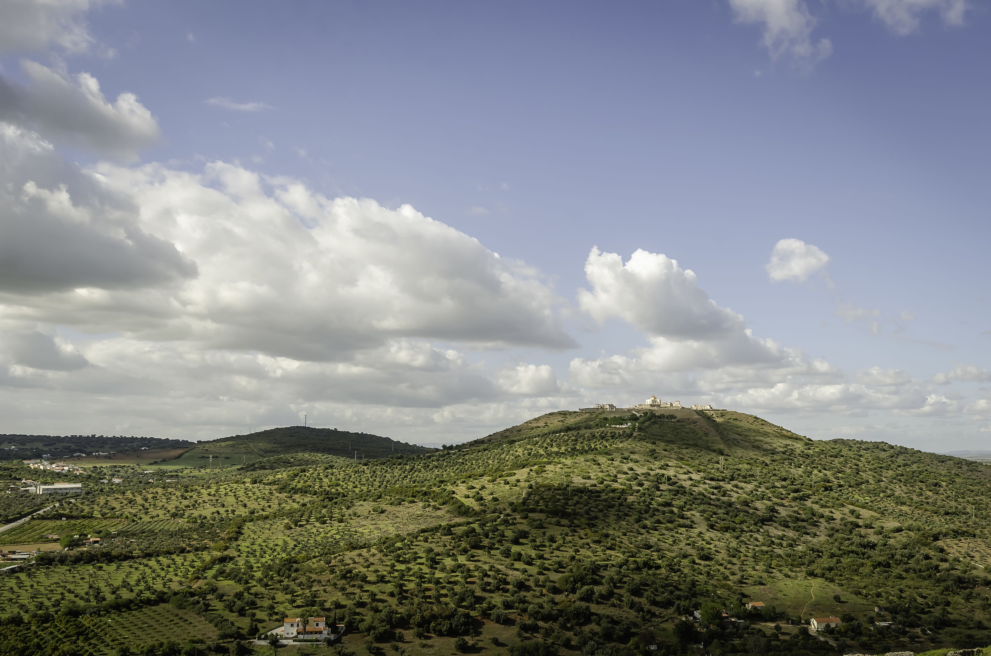 A hilly landscape with scattered buildings, likely a rural area with natural scenery.