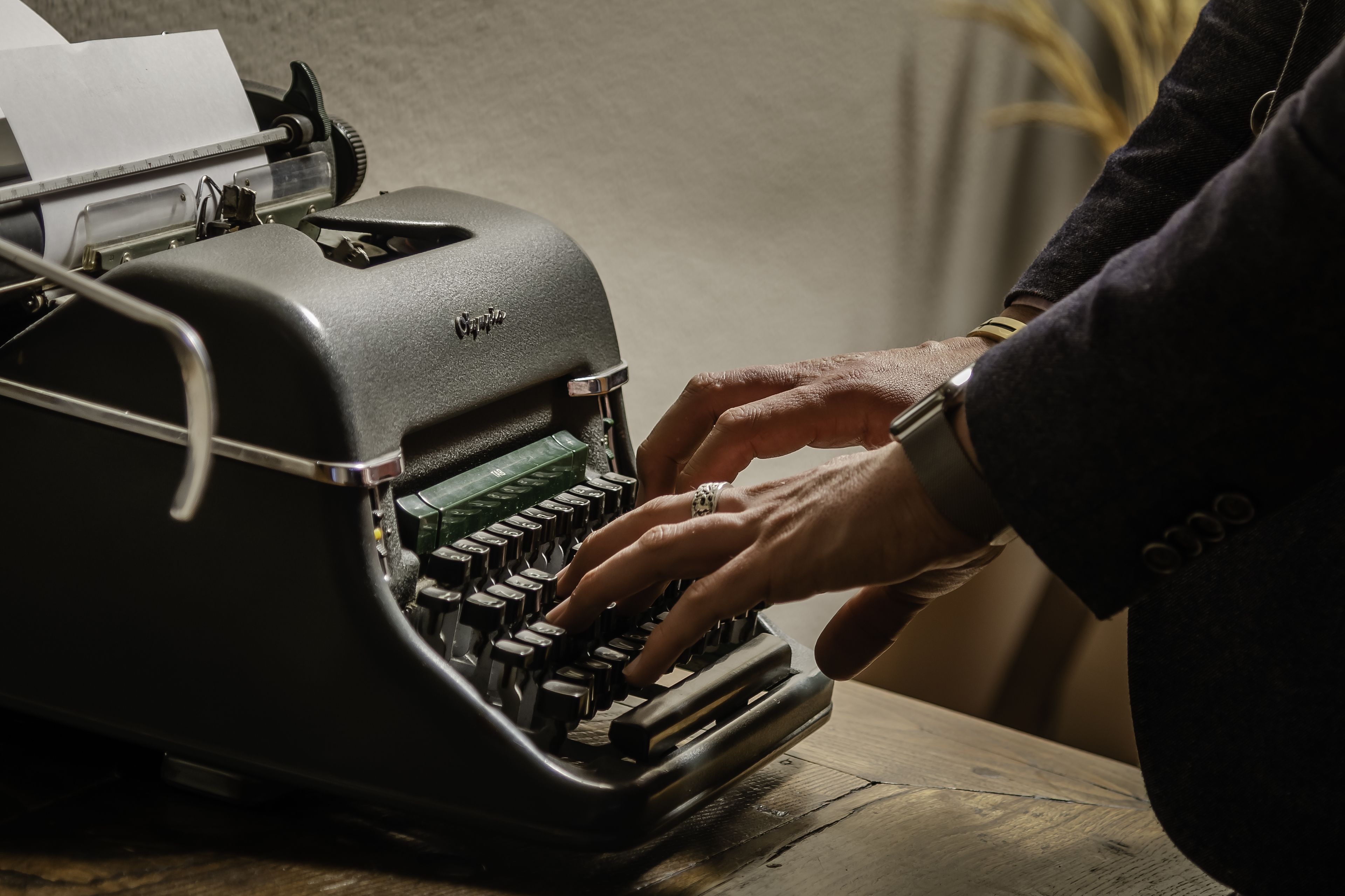 A vintage typewriter with a paper roll on its carriage.