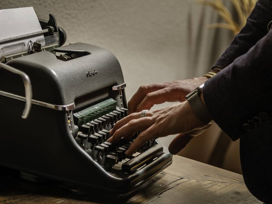 A vintage typewriter with a paper roll on its carriage.