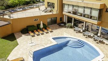Alberca al aire libre y camastros