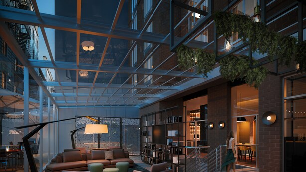 A spacious, modern lounge area with a glass ceiling, comfortable seating, and a visible staircase leading to an upper level.