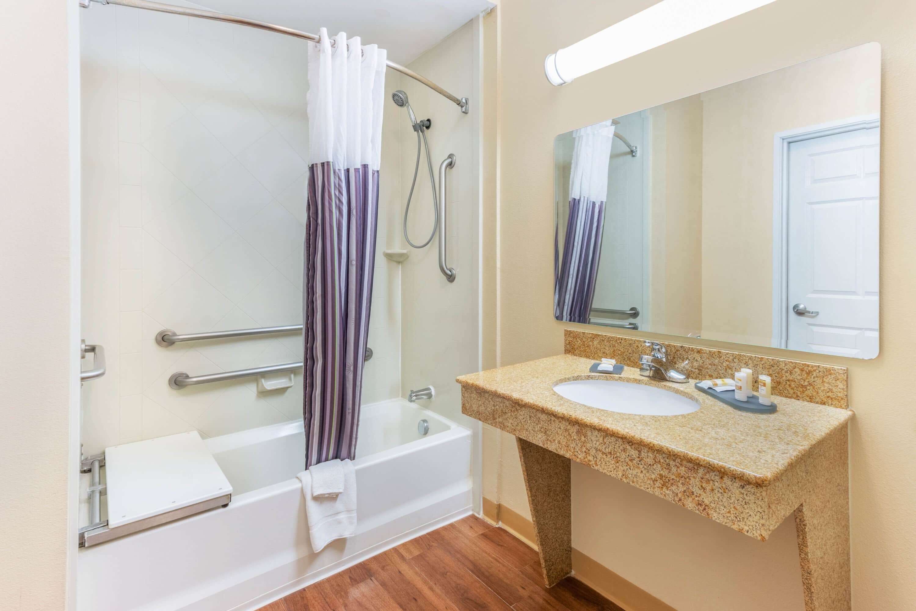 A bathroom with a bathtub, shower, and sink.