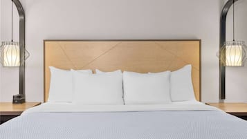 A neatly made bed with a wooden headboard and two bedside lamps.