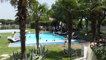 Una piscina al aire libre de temporada, sombrillas