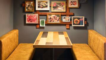 A dining area with a wooden table and two cushioned booths.