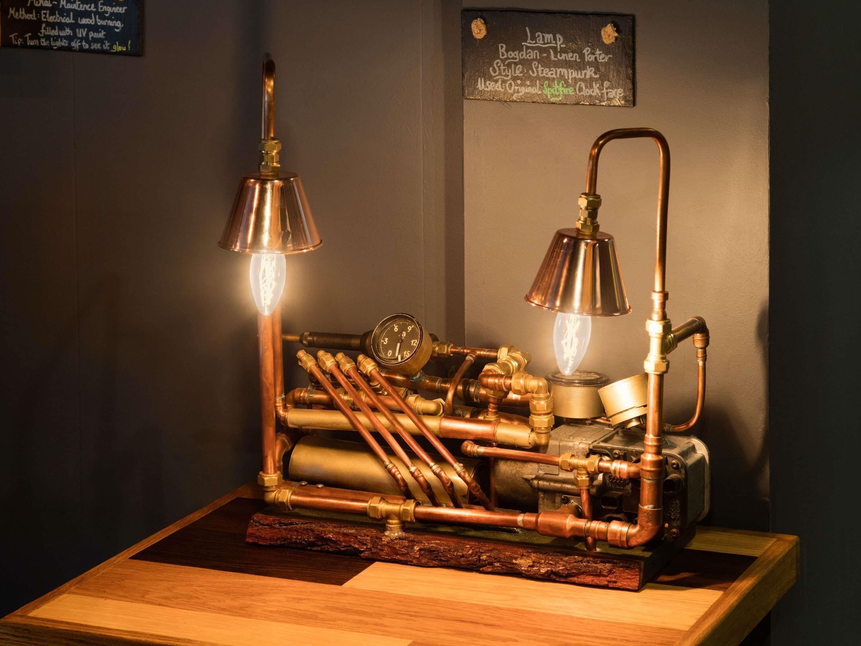 Luminária feita com tubos de cobre e mostrador de relógio, com base de madeira rústica.