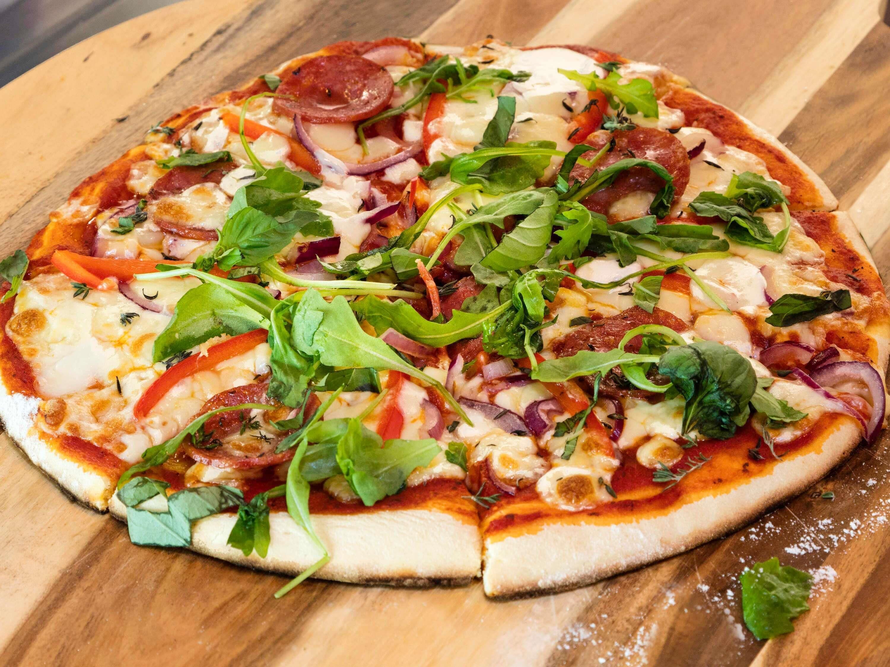 A pizza on a wooden board.