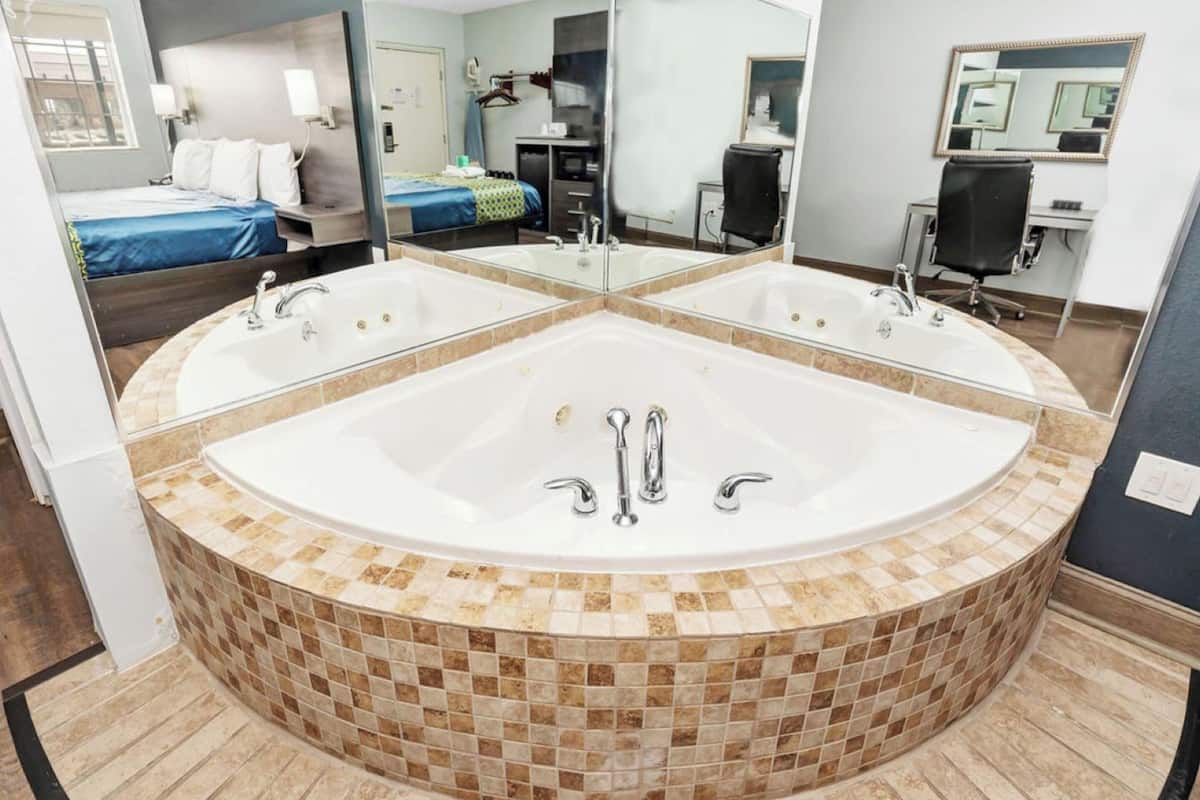 A modern bathroom with a large freestanding bathtub, a mirror, and a separate sink.