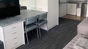 A modern kitchen with white cabinets, a built-in microwave, and a coffee maker. - Robetown Motel (Robe)