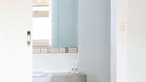 A bathroom with a modern design, featuring a large mirror, a sink, and a toilet. - Robetown Motel (Robe)