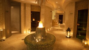A lobby with a mosaic fountain, tiled walls, and a staircase.