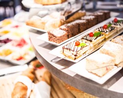 Un buffet con diversi dolci, tra cui torte e pasticcini.