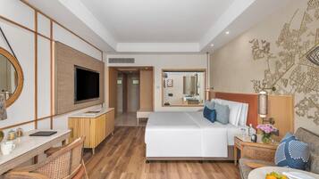 Habitación de hotel con cama, escritorio, televisor, espejo y una pared con diseño decorativo.