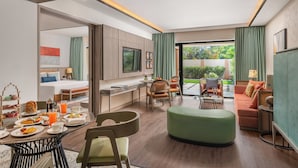 A modern hotel room with a dining area, a sofa, a TV, and a balcony. - Taj Alibaug Resort & Spa (Alibag)