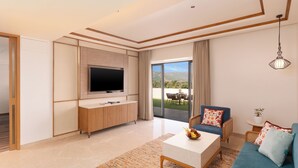 A modern living room with a flat-screen TV, a sofa, a coffee table, and a view of the outdoors. - Taj Alibaug Resort & Spa (Alibag)