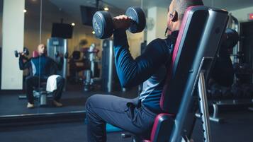Ein Fitnessstudio, in dem eine Person Gewichte hebt.
