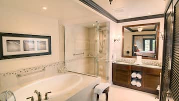 Une salle de bain moderne avec une baignoire sur pieds, une douche à parois de verre et un meuble-lavabo doté d’un miroir et d’un porte-serviettes.