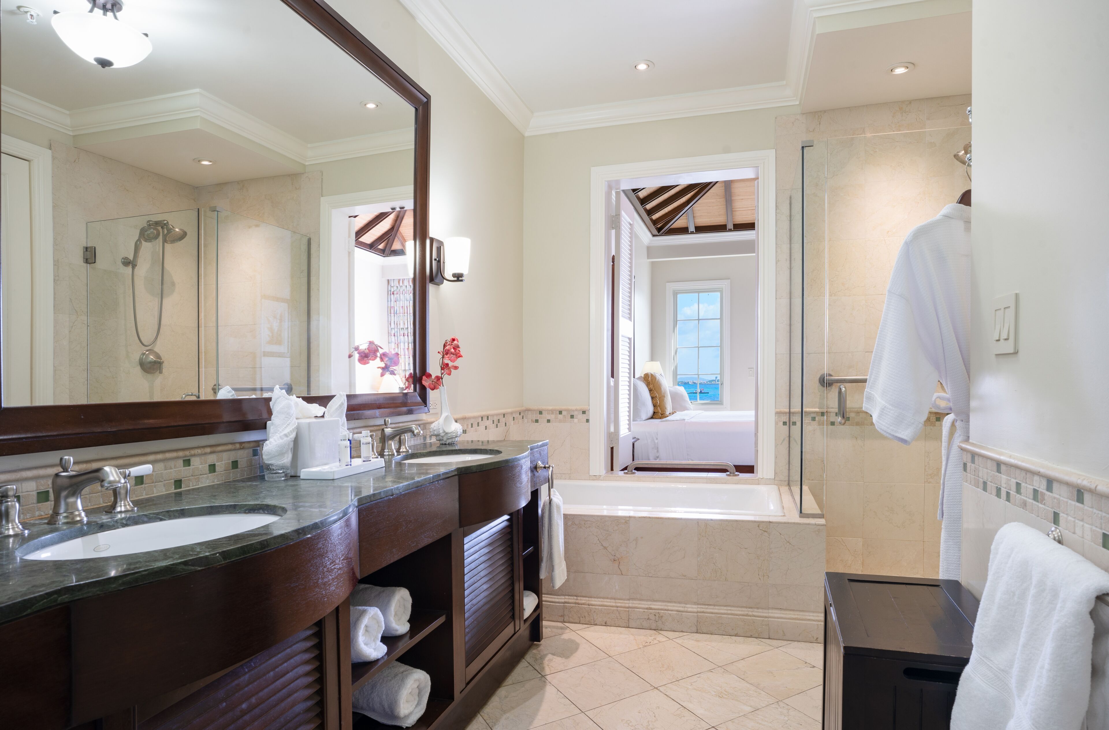 Un baño moderno con dos lavamanos, un espejo grande, una ducha y una bañera.