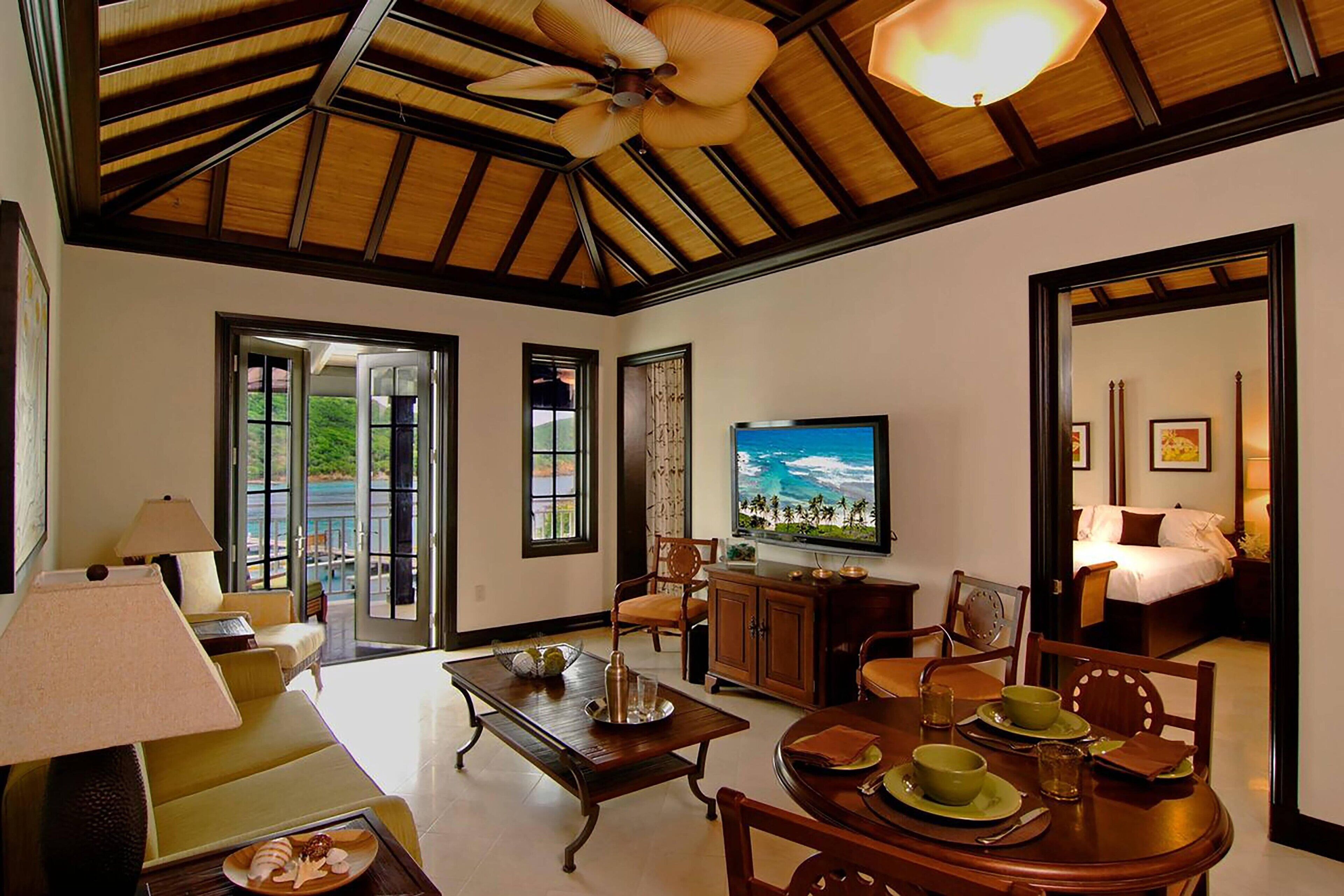 Un salón amplio con televisor grande, asientos cómodos y comedor.