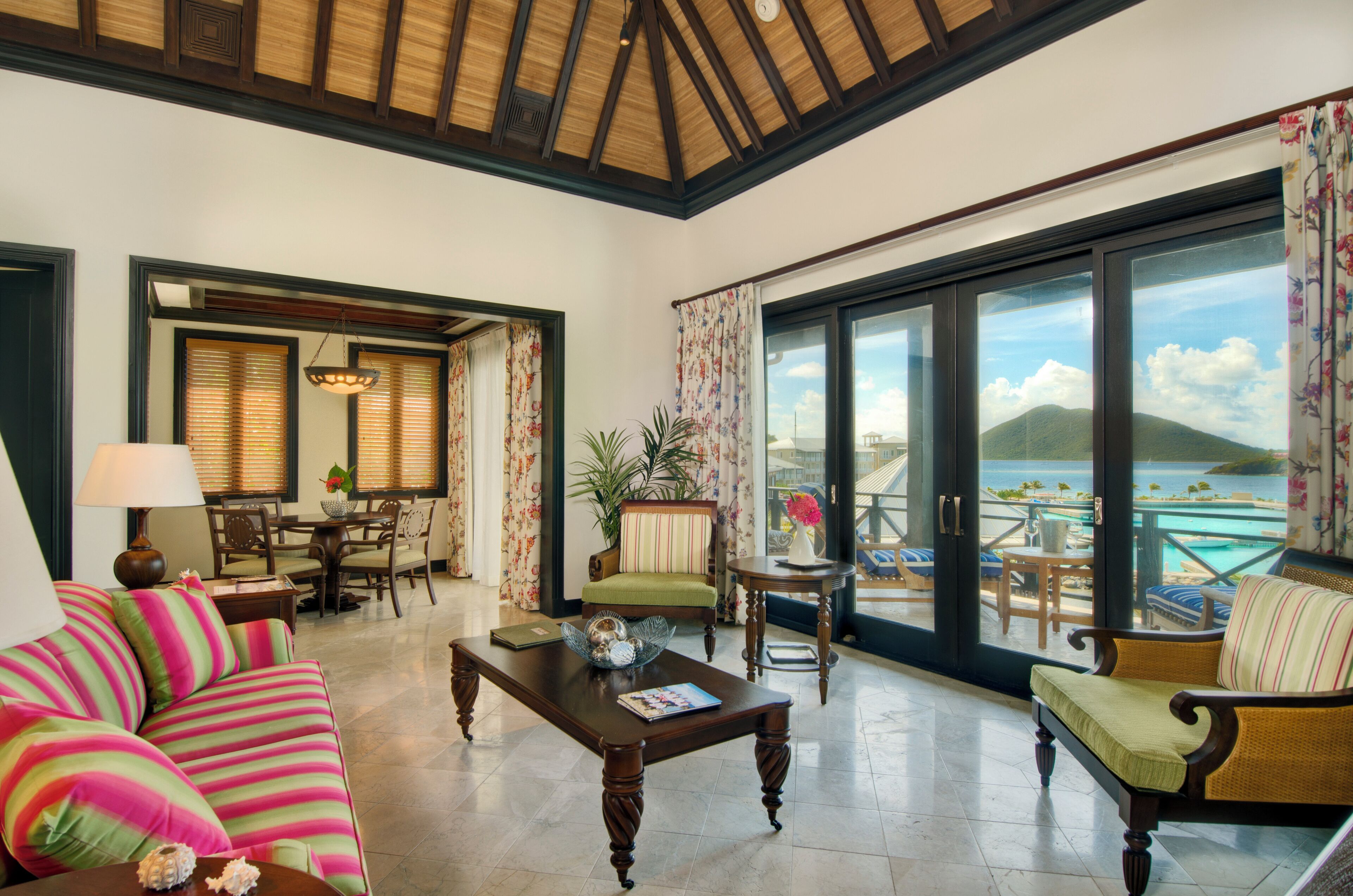 Un amplio salón con un ventanal grande que ofrece vistas panorámicas, amoblado con un sofá, un sillón y una mesa de centro.